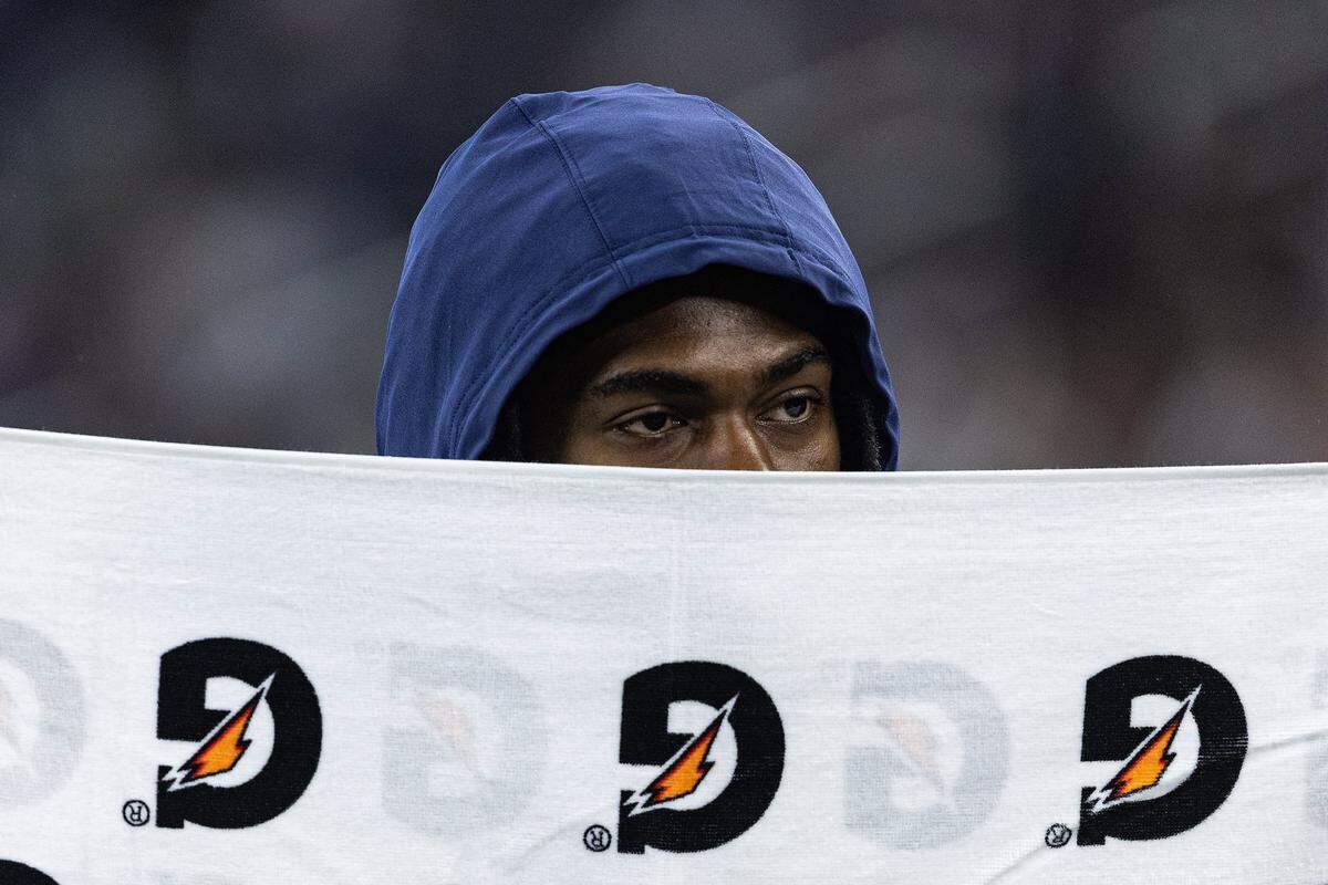 Cowboys cornerback Trevon Diggs (7) covers his face with a towel on the sidelines in the first half of an NFL preseason game between the Dallas Cowboys and the Atlanta Falcons at AT&T Stadium in Arlington on Friday, Aug. 22, 2025,