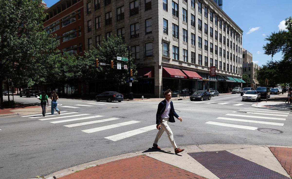Pedestrians cross Throckmorton and West Fourth Streets on June 27 in downtown Fort Worth. People returning to the office has been a main driver of downtown traffic.