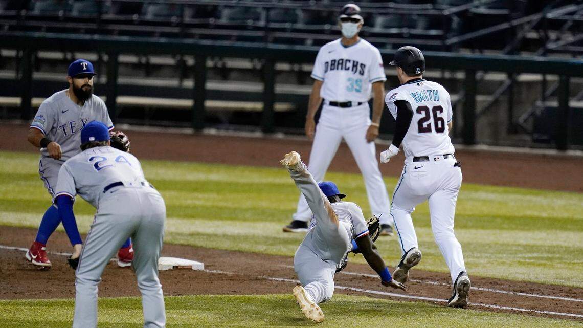 Arizona Diamondbacks’ Pavin Smith avoids Texas Rangers first baseman Sherten Apostel, front right, for an infield single as Rangers starting pitcher Jordan Lyles and second baseman Rougned Odor, left, and Diamondbacks first base coach Dave McKay watch during the sixth inning Tuesday night. Arizona scored four runs in the inning and beat Texas 7-0.