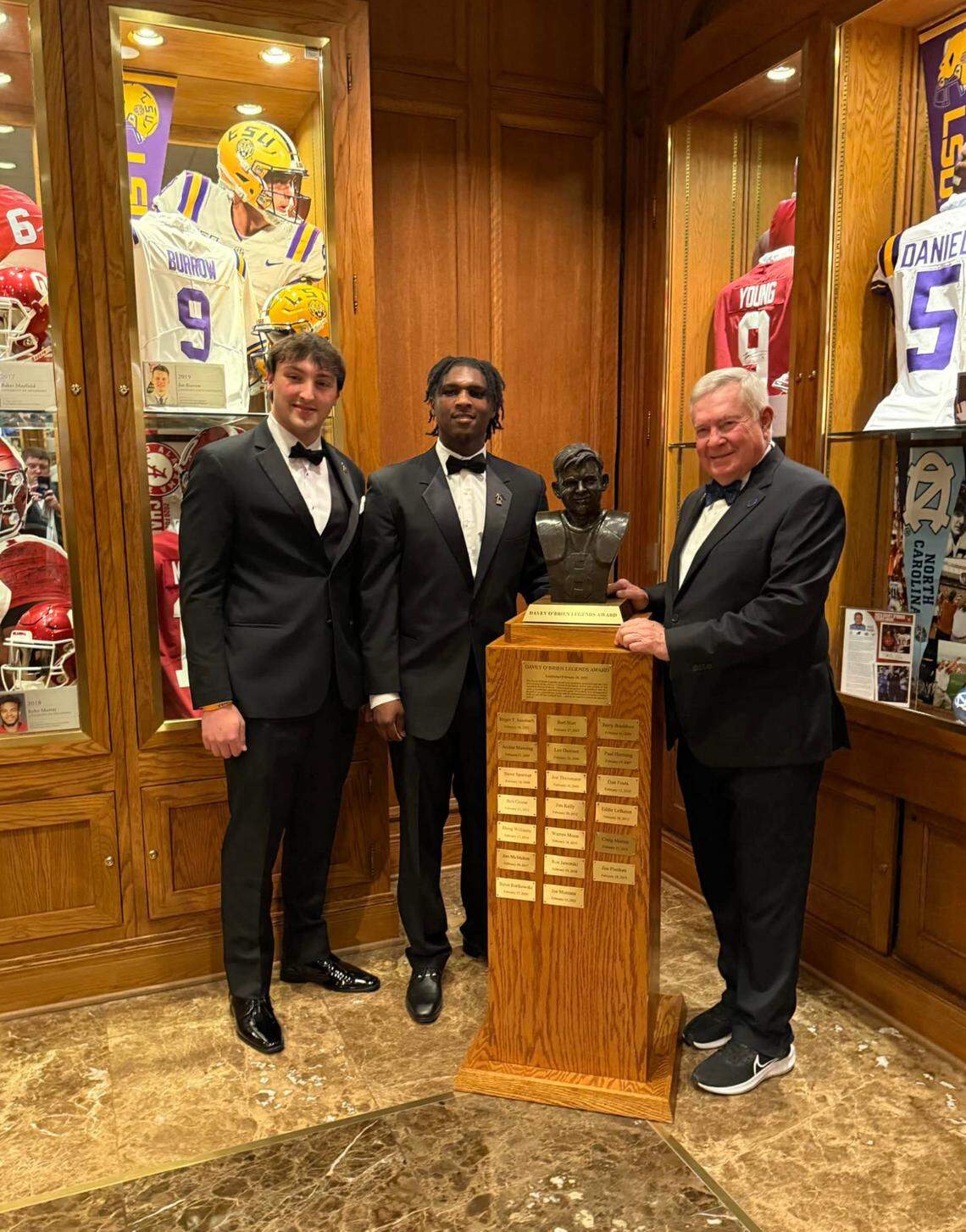 Clay Lindmark (High School Scholarship Award winner), Cameron Ward (National Quarterback Award) and Mack Brown (Legends Award) and Clay Lindmark (High School Scholarship) pose in front of the Davey O’Brien trophy on Monday at the Fort Worth Club. 