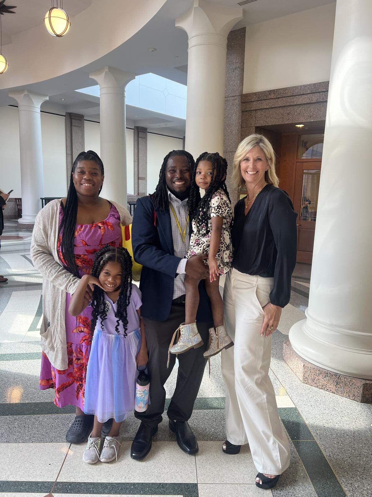 Aric Dunmore, with his wife and two daughters, and Traci Berry, CEO and superintendent of New Heights.