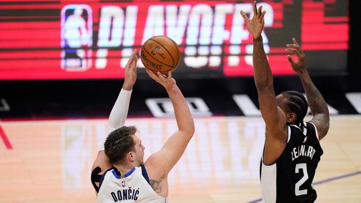 Dallas Mavericks guard Luka Doncic, left, shoots as Los Angeles Clippers forward Kawhi Leonard defends during the first quarter of Game 5 Wednesday night at the Staples Center. Doncic had a career postseason-high 19 points in the quarter.