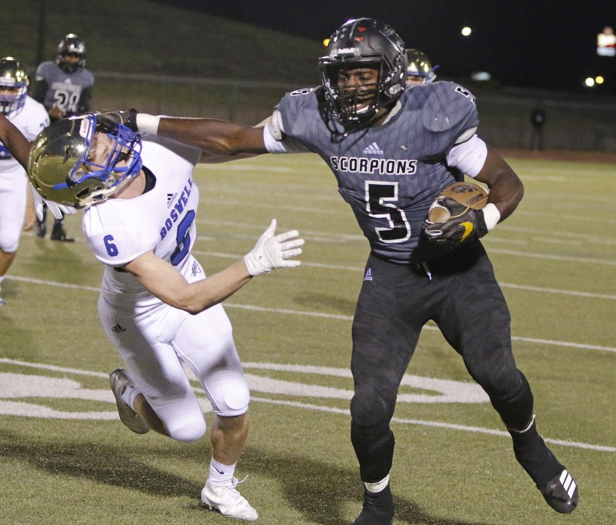 South Hills running back Anthony Watkins (5) stiff arms Boswell wide receiver Jordan Naylor (6) for yardage during the first half of a high school football game at Clark Stadium Thursday, Oct. 25, 2018. South Hills led 13-9 at the half. (Special to the Star-Telegram Bob Booth)
