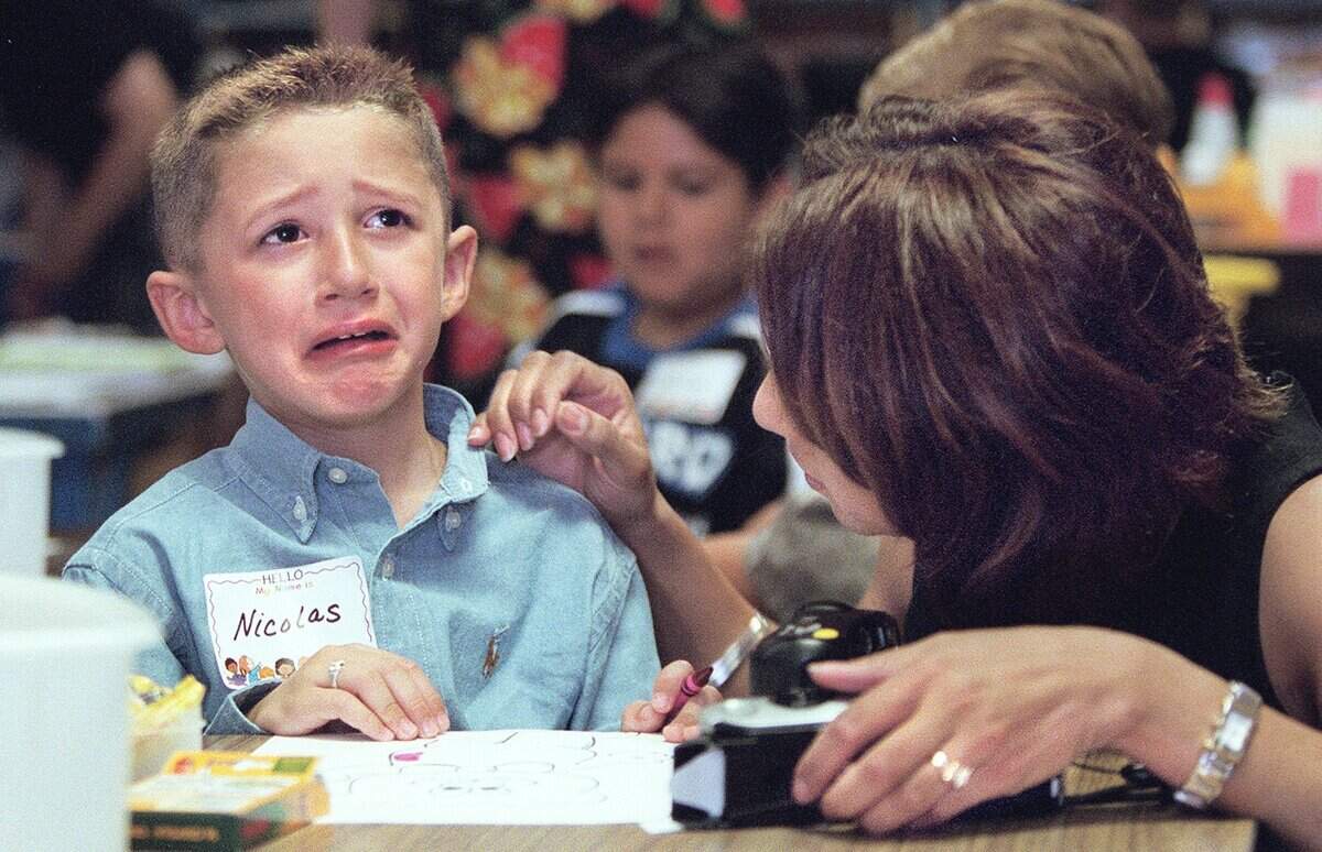 Aug. 9, 2000: Nicolas Anderson kept a brave face on until it was time for his mom and dad, Trent and Annie Anderson, to leave teacher Cheryl Young’s classroom. His mother comforts Nicolas, who, almost as soon as she left the room, was happily coloring away with his new classmates. This was the first day of school for students at Charlotte Anderson Elementary in the Mansfield ISD.