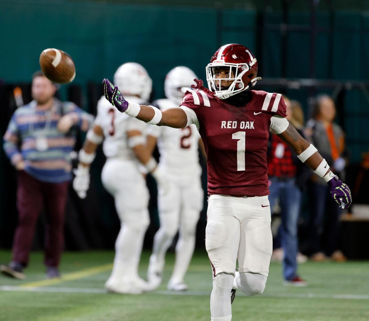 Red Oak wide receiver Taz Williams (1) tosses the ball to the back judge after scoring in the first half of a Conference 5A Division 1 UIL Regional football playoff game at Choctaw Stadium in Arlington, Texas, Friday, Oct. 24, 2023.