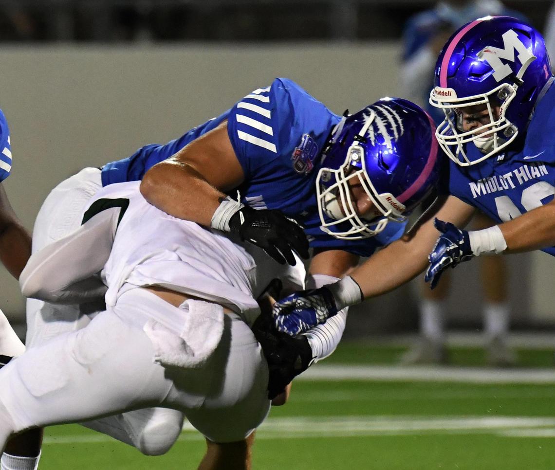 Midlothian’s Kaleb Tompkins, left and Andrew Colman tackle Birdville quarterback Aiden Dollar for a loss in the second quarter of their Division 1 District 4-5A football game Thursday, October 22, 2020 at the Midlothian Multi-Purpose Stadium in Midlothian, Texas. Special/Bob Haynes