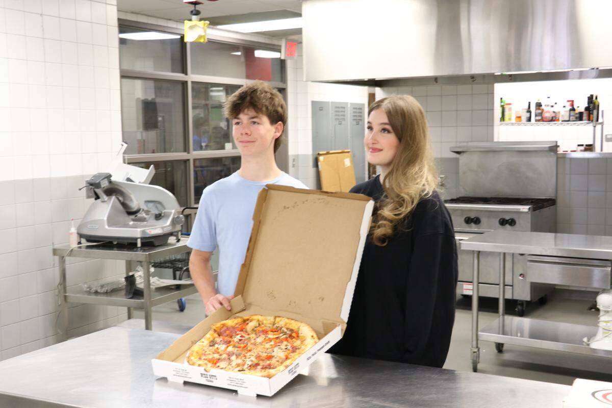 Sophomore Colt McMaster and senior Emma Balding created the Concrete Jungle pizza, which is topped with meat, Alfredo and marinara sauces, mozzarella cheese, garlic chicken, red bell peppers, sausage, capicola, hot honey and red pepper flakes.
