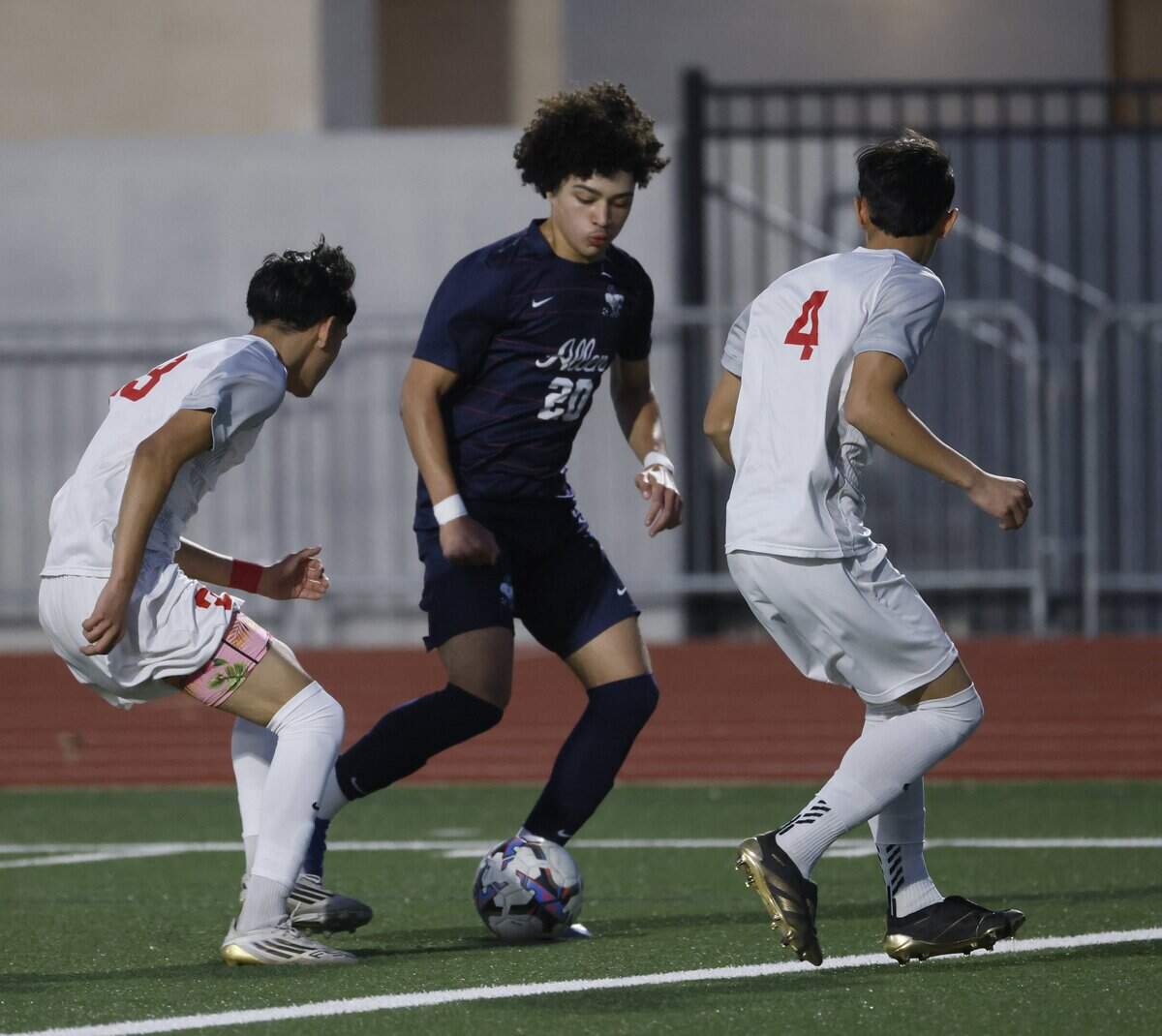 Allen midfielder Ivan Wright (20) gets between Arlington Sam Houston Christopher Olvera (23) and Angel Maldonado (4) during the first half of a UIL area round boys soccer playoff game at Tommy Standridge Stadium in Carrollton, Texas, Tuesday, March 24, 2026.