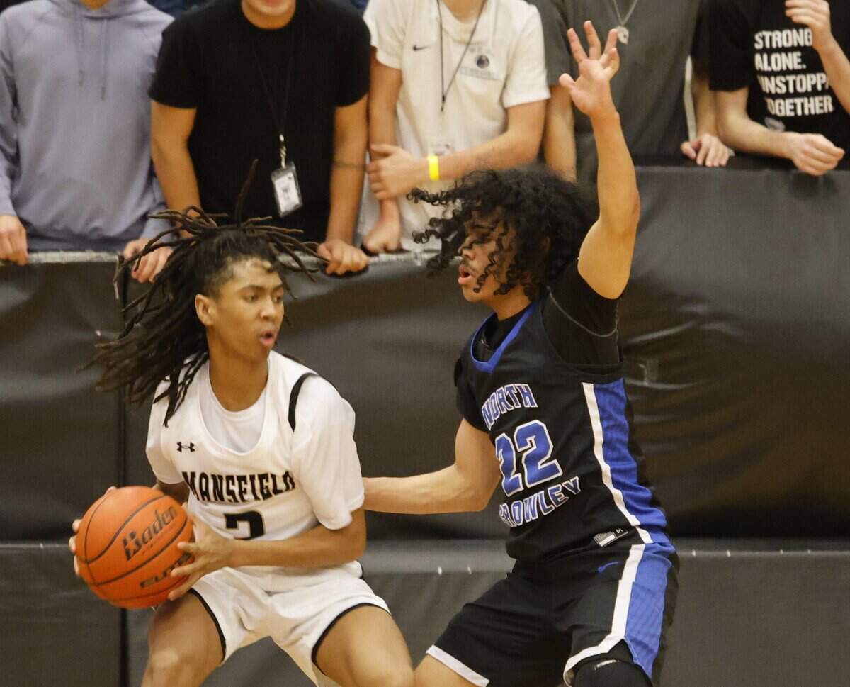 Mansfield's Zion Robinson (2) grabs a rebound in front of North Crowley guard Isaak Hayes (22) during the first half of a UIL boys basketball game between North Crowley and Mansfield at Mansfield High School in Mansfield, Texas, Tuesday Jan. 20, 2026
