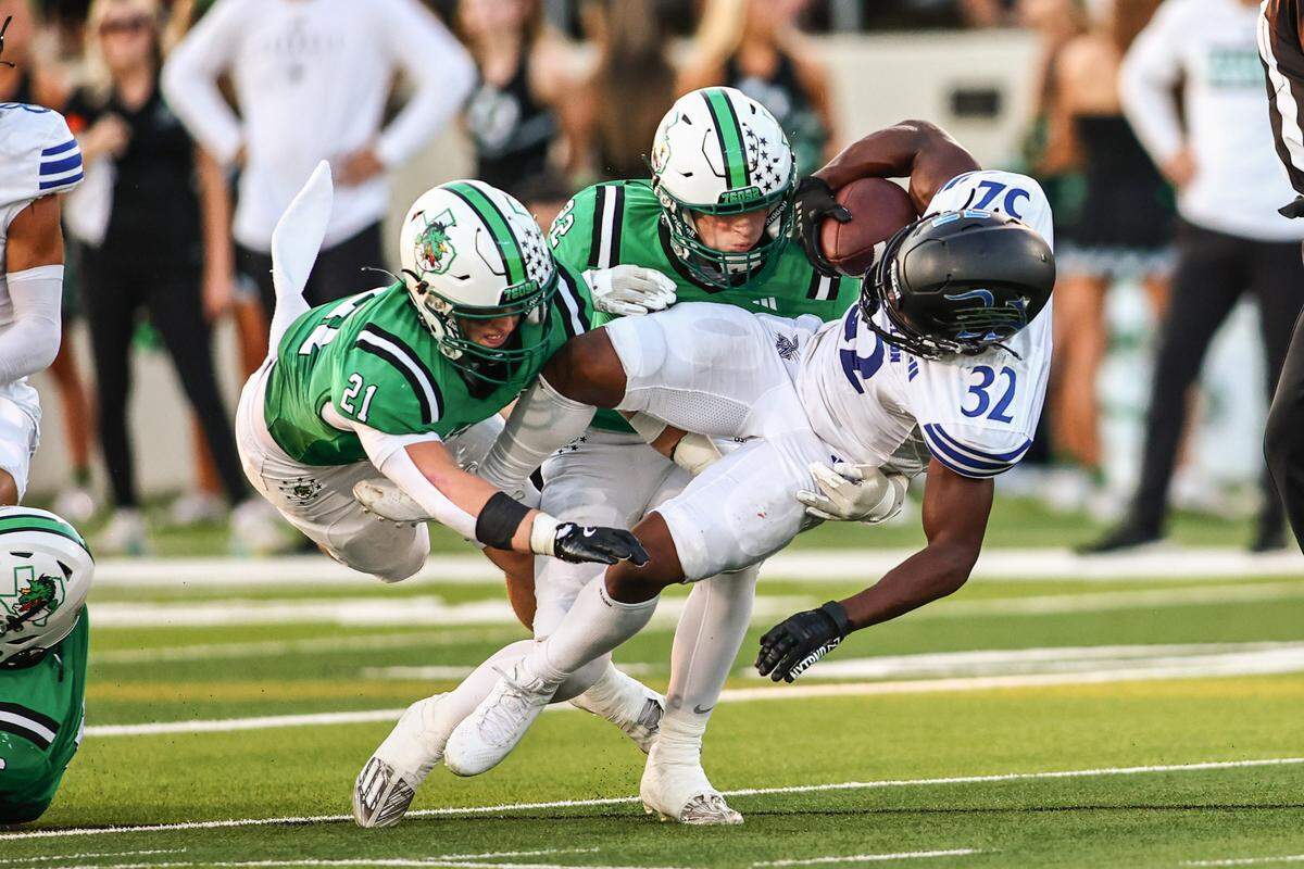 Trophy Club Byron Nelson running back Sean Robinson (32) gets upended by Southlake Carroll’s Robbie Ladd (21) and Brody Bourgeois (22) in a District 4-6A game on Friday, September 13, 2024 at Dragon Stadium in Southlake, Texas.