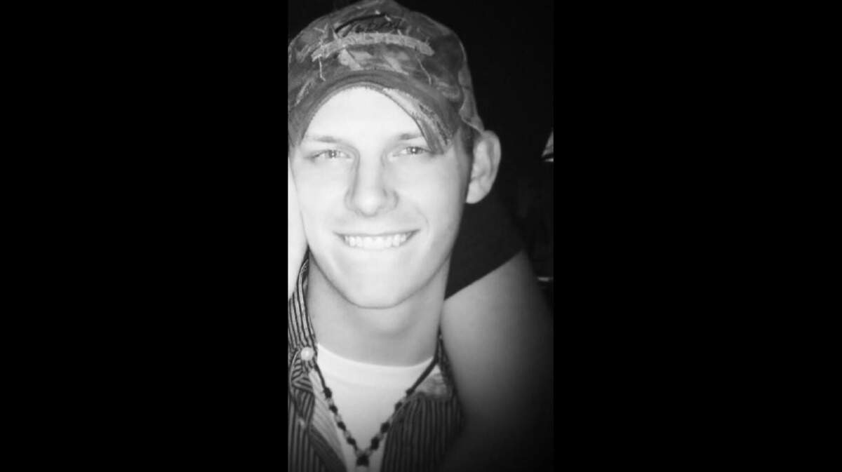 Jordan Hightower smiles in a baseball cap in this photo provided by his family. The 31-year-old was killed during a robbery at an Arlington convenience store where he worked.