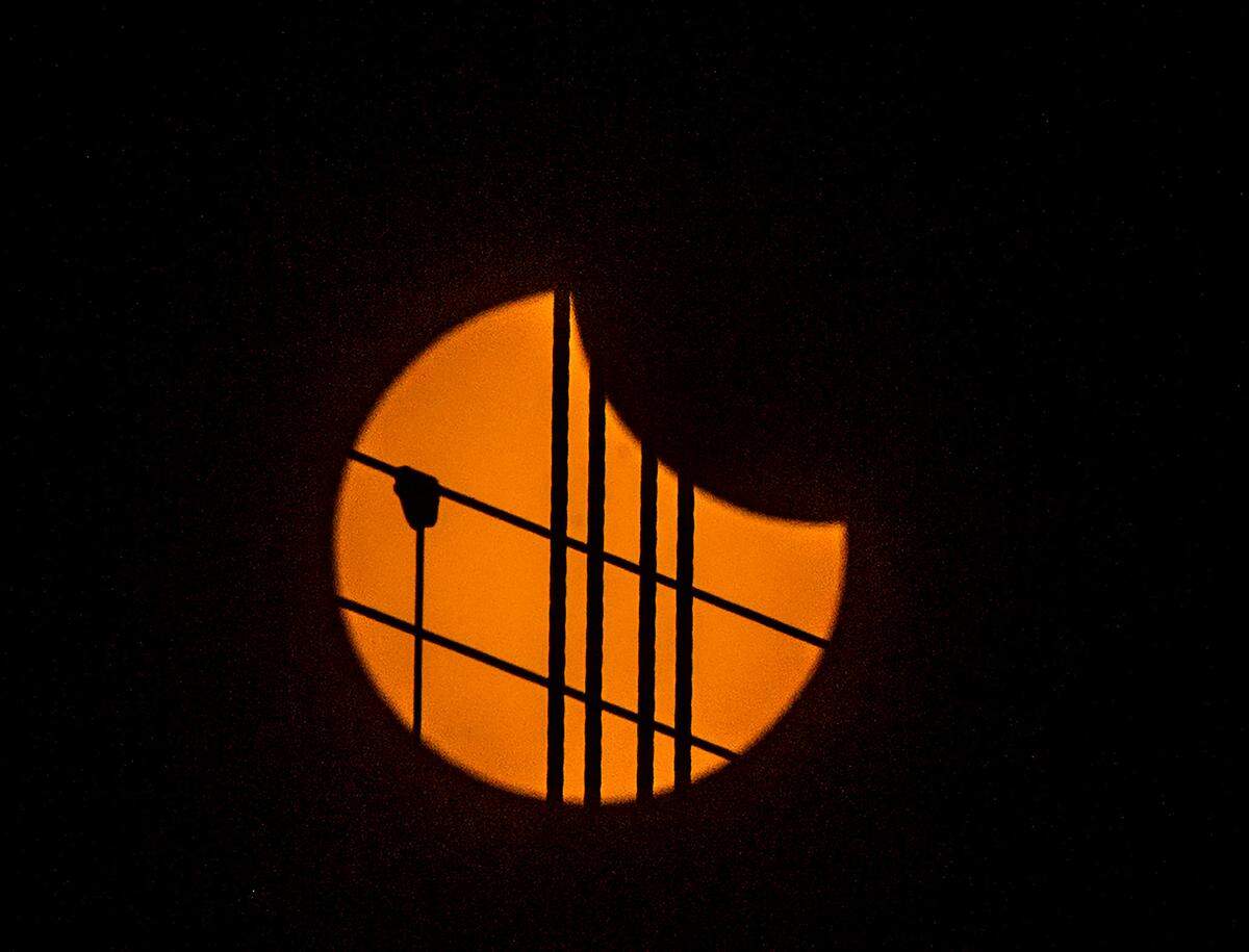 Cables of the Tacoma Narrows Bridge in Gig Harbor, Wash., are silhouetted by the sun as the shadow of the moon begins to move Monday, Aug. 21, 2017. The next total solar eclipse will be visible in Texas April 2024.