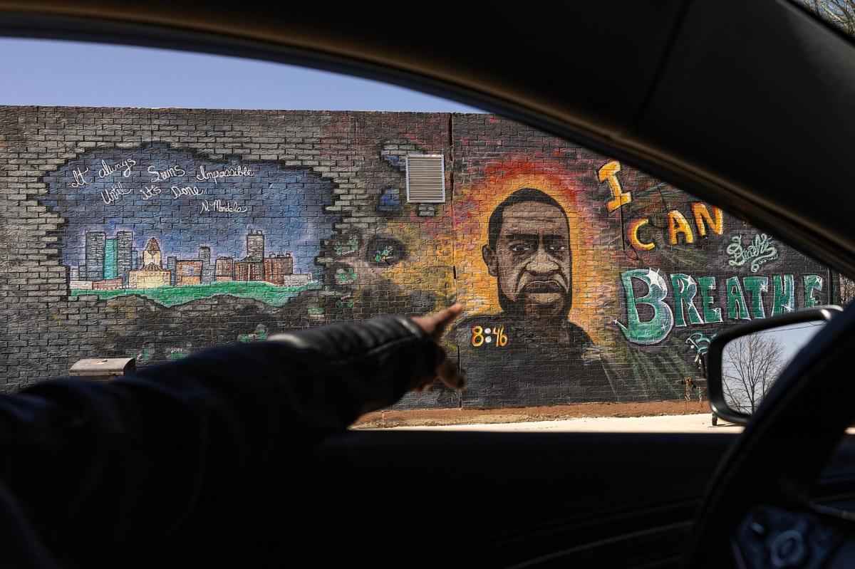 Regina Davis, the secretary of the Fairhaven Neighborhood Association, points at a George Floyd mural in the neighborhood.