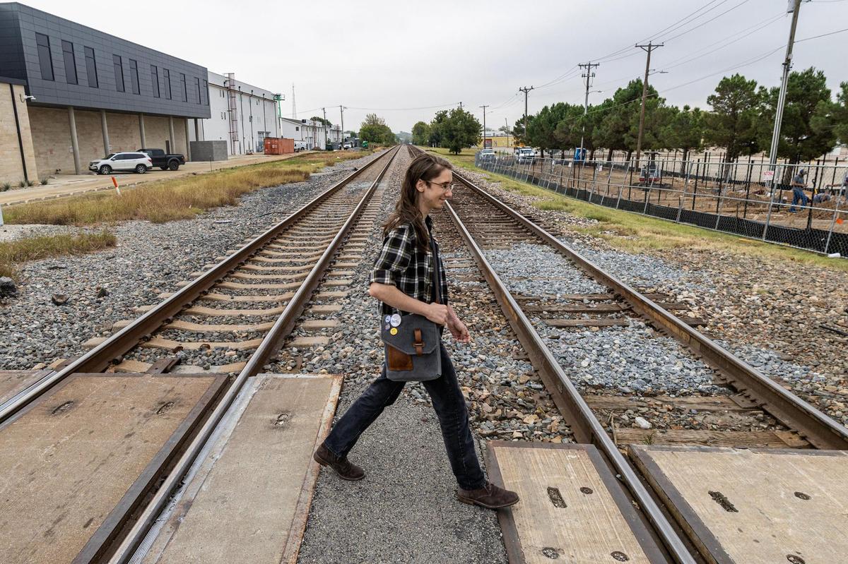 Hyacinth Szabó, the President of Walkable Arlington and senior at UT Arlington, walks across the railroad on E Mesquite Street. The track cuts splits downtown Arlington in half, hindering connectivity between different parts of the district.