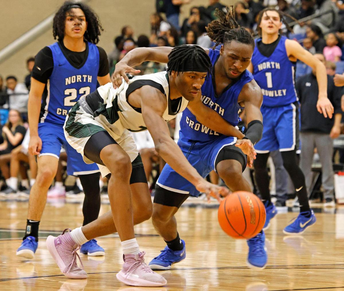 Lake Ridge forward Ezenwa Nwakamma (10) and North Crowley wing Chris Shelby (14) battle for a loose ball during a UIL boys basketball game at Lake Ridge High School in Mansfield, Texas, Friday, Jan. 24, 2025.