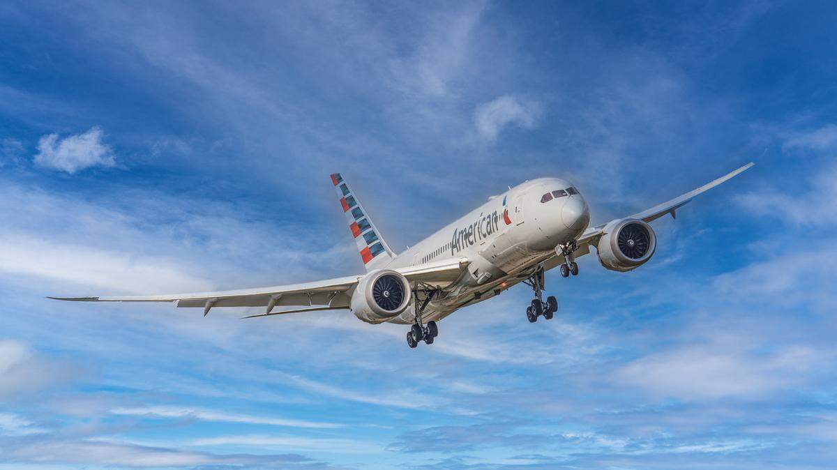 An American Airlines plane soars in the sky.