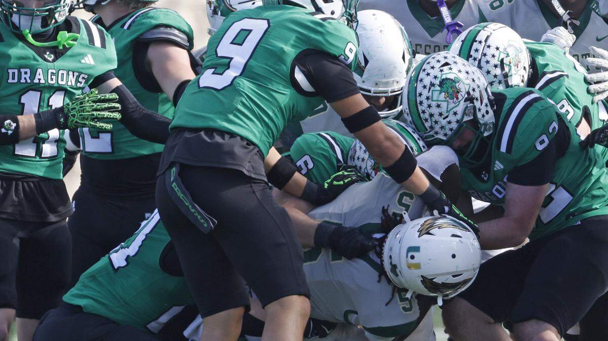 DeSoto running back Sarod Baker is engulfed by the Southlake Carroll defense during a 6A Division 2 playoff game in December. All 6A schools are required to report concussion data to the UIL.