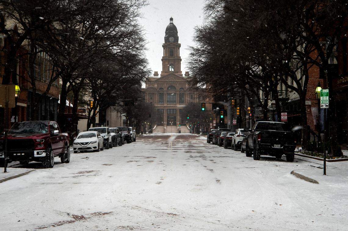 Snow falls along Main Street near the Tarrant County Courthouse on Feb. 14, 2021 in Fort Worth.
