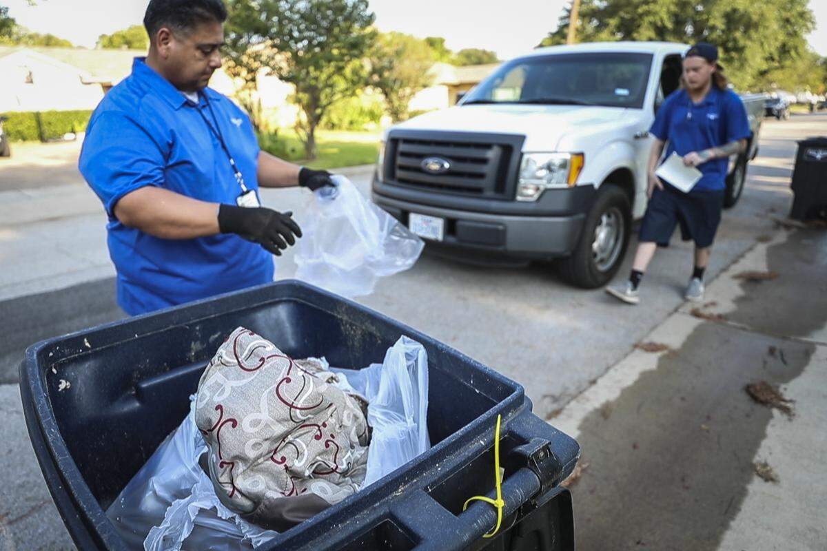 Daniel Reyna and Brent Wedell with the Blue Crew bag non-recyclable items from the blue bin Thursday, Aug. 29, 2019, in Fort Worth.