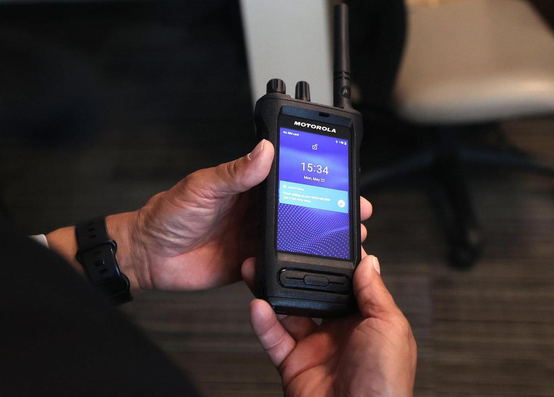 Daniel Garcia, security director of the Fort Worth school district, right, shows U.S. Sen. John Cornyn a smart radio on Monday. School officials plan to use $359,000 in money from the Bipartisan Safer Communities Act to purchase the radios so school security officers are able to maintain better situation awareness.