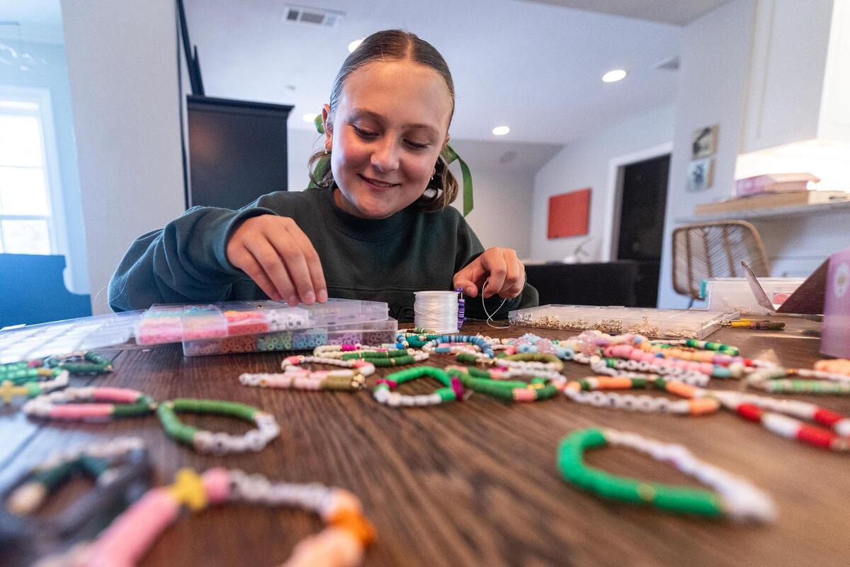 Max Grieshaber, 11, of Fort Worth makes bracelets in her home on Tuesday, July 15. The Grieshaber family is selling bracelets to raise money for victims of the flooding near Kerrville, Texas.