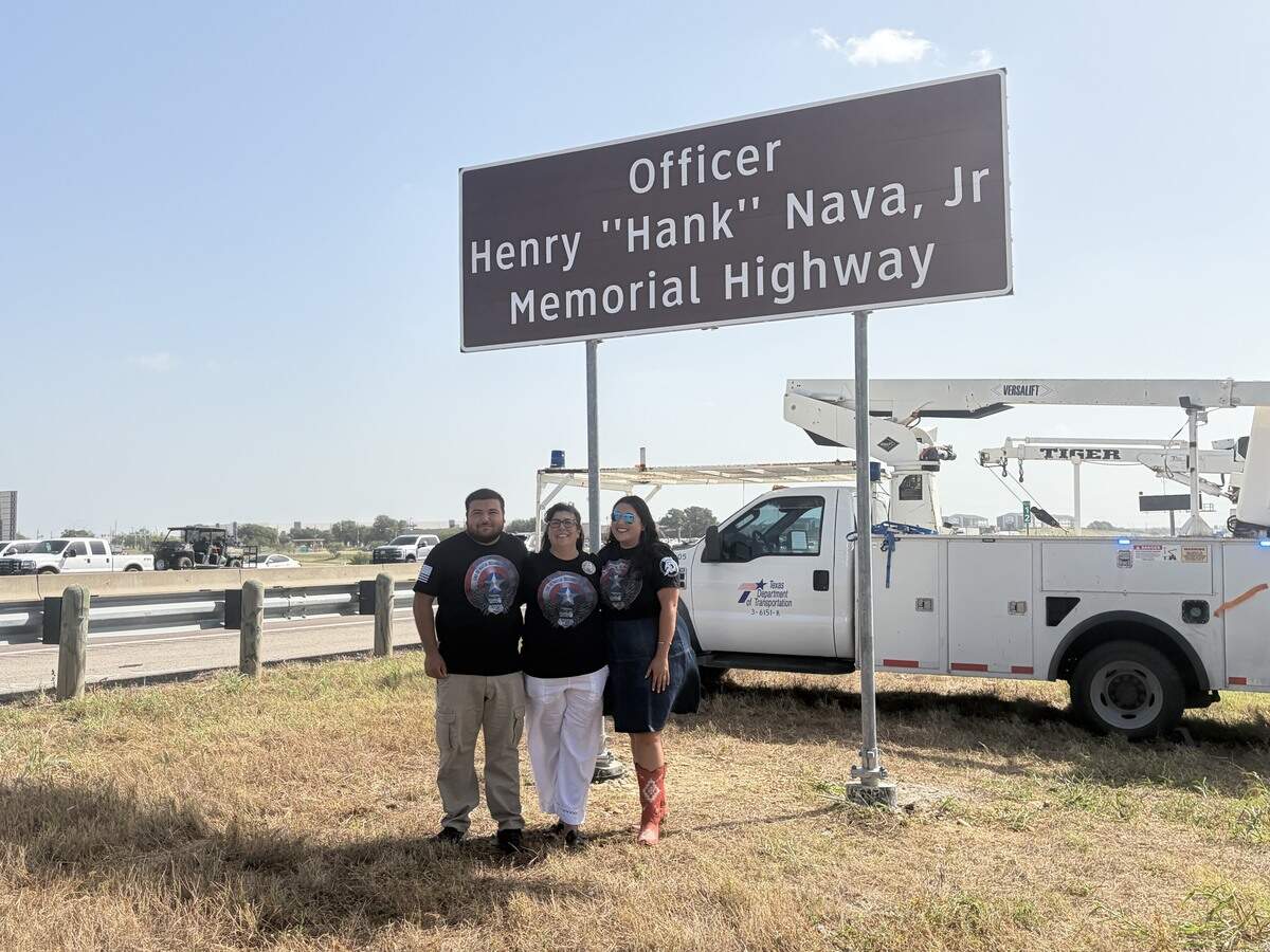 Fort Worth police Officer Henry “Hank” Nava Jr.’s son, Henry Nava III; his widow, Teresa Nava-Salazar; and daughter, KayLeigh Nava; stand in front of his memorial sign on Monday morning, June 29, 2026, during an unveiling ceremony. Nava was shot while serving a warrant and died from his injuries in December 2005. The Fort Worth City Council unanimously approved a memorial marker agreement last November that allowed the Texas Department of Transportation to place signs honoring Nava along the section of Loop 820 between Interstate 35W and Marine Creek Parkway.
