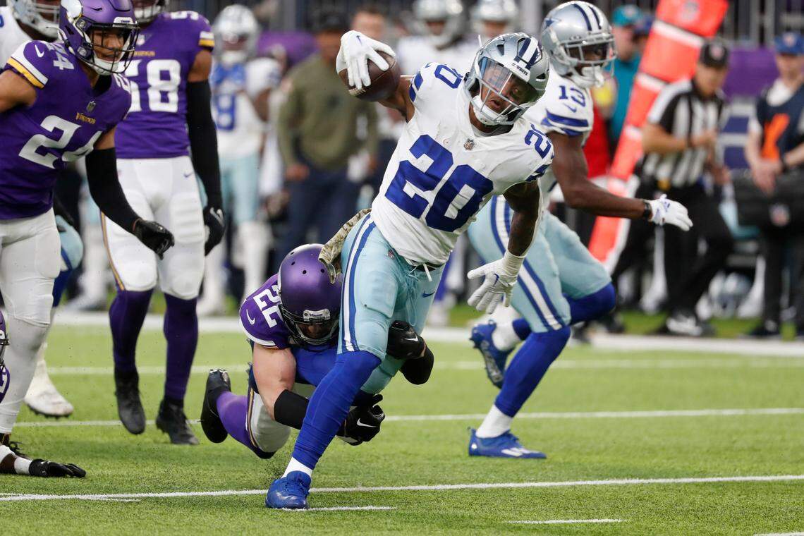 Dallas Cowboys running back Tony Pollard (20) tries to break a tackle by Minnesota Vikings safety Harrison Smith (22) during the first half of an NFL football game, Sunday, Nov. 20, 2022, in Minneapolis. (AP Photo/Bruce Kluckhohn)