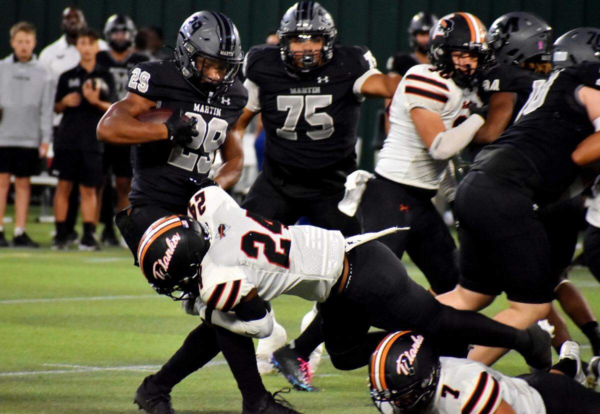 Arlington James Martin running back Javian Jones-Priest is tackled by Haltom’s Amaree Jackson in the first quarter of a UIL football game at Choctaw Stadium on Friday, Oct. 18, 2024.