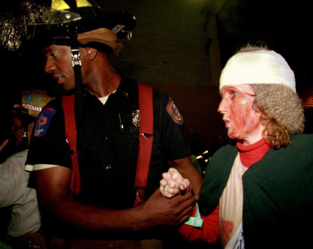 A fort Worth firefighter helps a woman into an ambulance at the Farrington Field triage unit set up to help many of the people those injured in the Mayfest hailstorm May 5, 1995, in Trinity Park.
