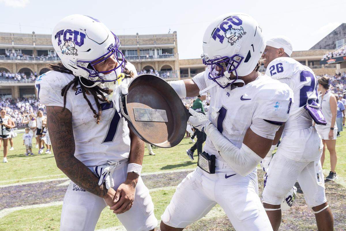 TCU wide receiver Jordan Dwyer (7) and safety Austin Jordan (1) celebrate with the Iron Skillet after defeating SMU 35-24 at Amon G. Carter Stadium in Fort Worth on Saturday, Sept. 20, 2025.