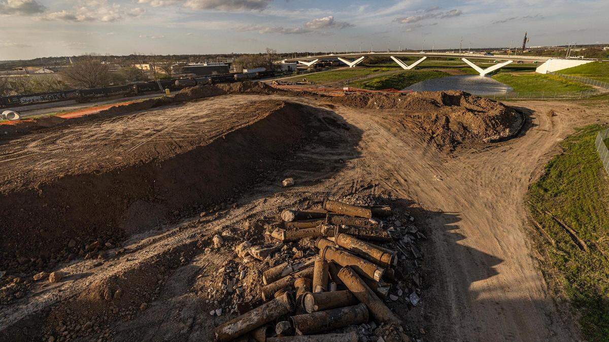 A construction ditch under a bridge at sunset