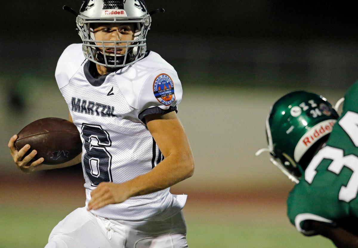 Martin quarterback Zach Mundell (6) attempts to avoid the tackle of Arlington linebacker EJ Higgins during the first half of Friday’s game at UTA Maverick Stadium in Arlington, Texas, Oct. 18, 2019.