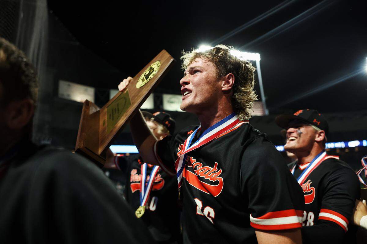 Aledo designated hitter Lucas Nawrocki holds the championship trophy to the Aledo fans after the Class 5A Division I playoffs state championship game at Dell Diamond Stadium on Friday, June 6, 2025.