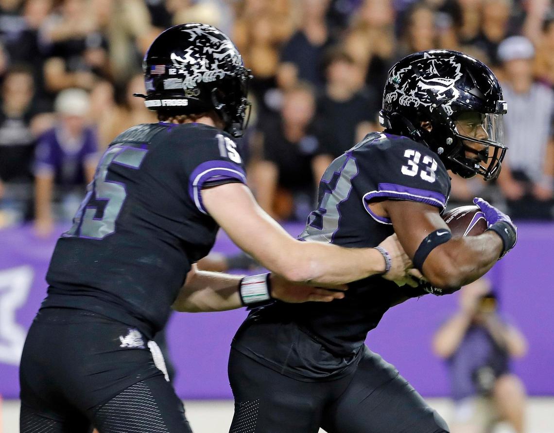 TCU quarterback Max Duggan (15) hands the ball to running back Kendre Miller (33) in the first half of a NCAA football game at Amon G. Carter Stadium in Fort Worth, Texas, Saturday, Oct. 22, 2022. Kansas State led TCU 28-17 at the half. (Special to the Star-Telegram Bob Booth)