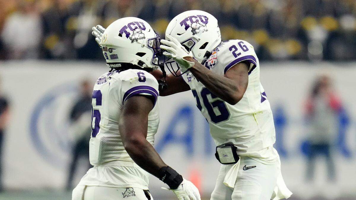 TCU safety Bud Clark (26) and linebacker Jamoi Hodge celebrates a goal line stop against Michigan in the Fiesta Bowl on Dec. 31, 2022.