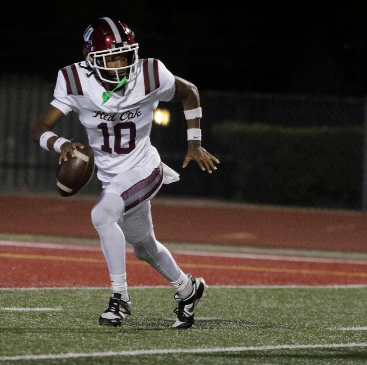 Red Oak’s Billy Middleton escapes the pocket during a UIL football game at Burleson ISD Stadium on Friday October 25, 2024.