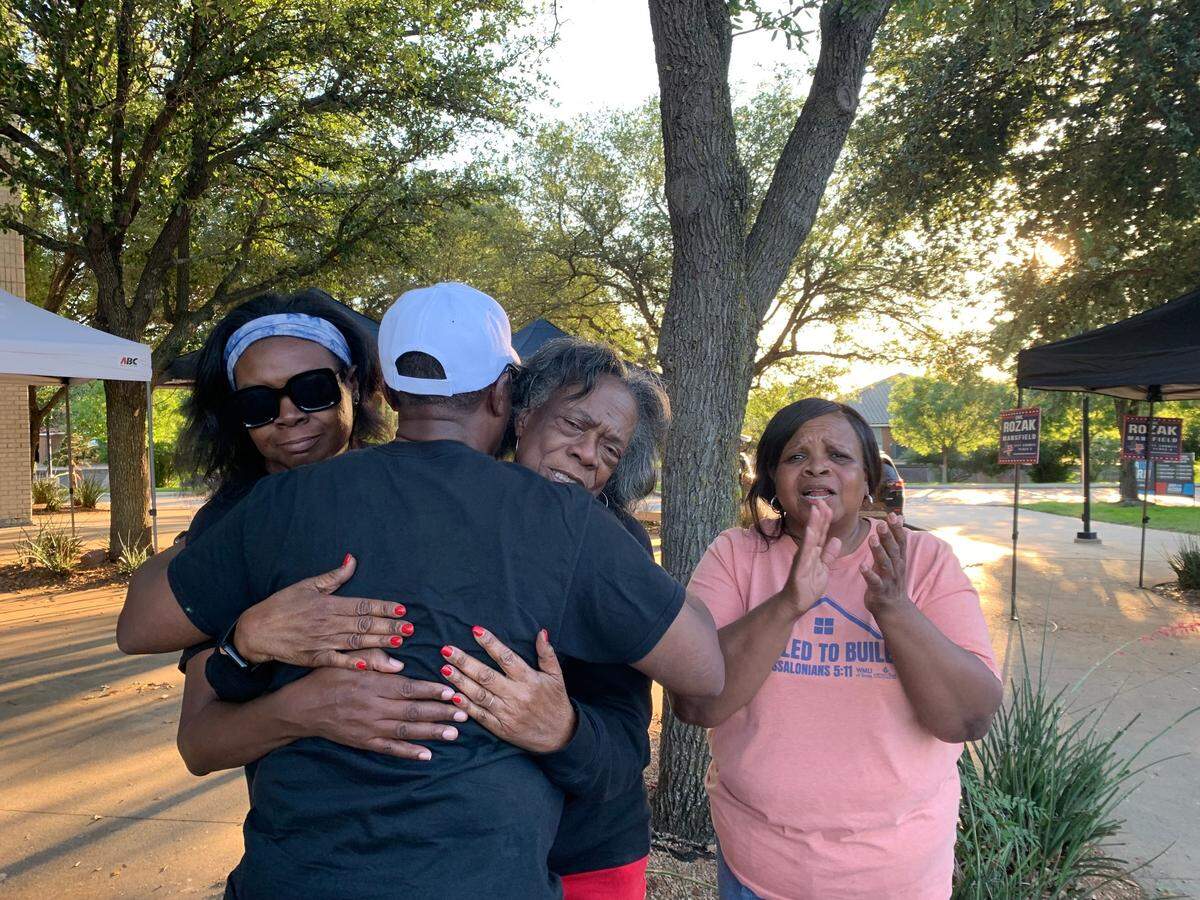 Incumbent Michael Evans embraces members of his campaign team after early voting data reveals his lead in the Mansfield mayoral race on May 3, 2025.