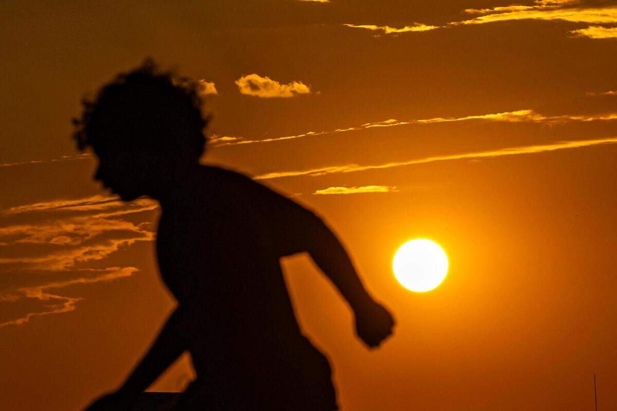 A skater is silhouetted as the sun begins to set at Chisholm Trail Skate Park in Fort Worth on Tuesday, Aug. 29, 2023.