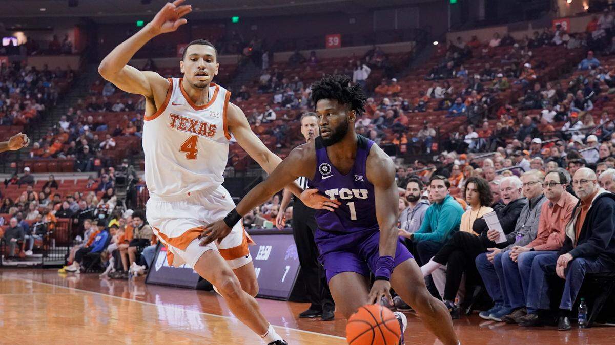 TCU guard Mike Miles (1) drives past Texas forward Dylan Disu (4) during the first half of Wednesday’s game in Austin.