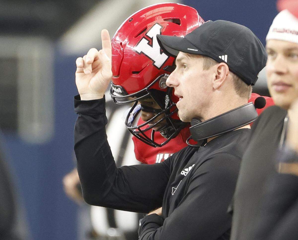 Kilgore head coach Clint Fuller talks to quarterback Kayson Brooks (2) on the sidelines as his defense faces Stephenville during the second half of the UIL Class 4A Division I championship game on Friday Dec. 19, 2025 at AT&T Stadium in Arlington, Texas.