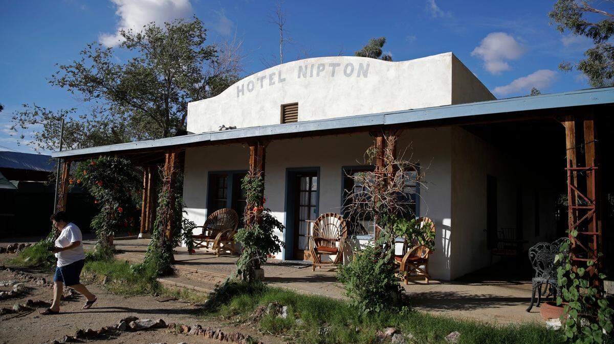 A woman walks out of the Hotel Nipton, Thursday, Aug. 3, 2017, in Nipton, Calif. (AP Photo/John Locher)