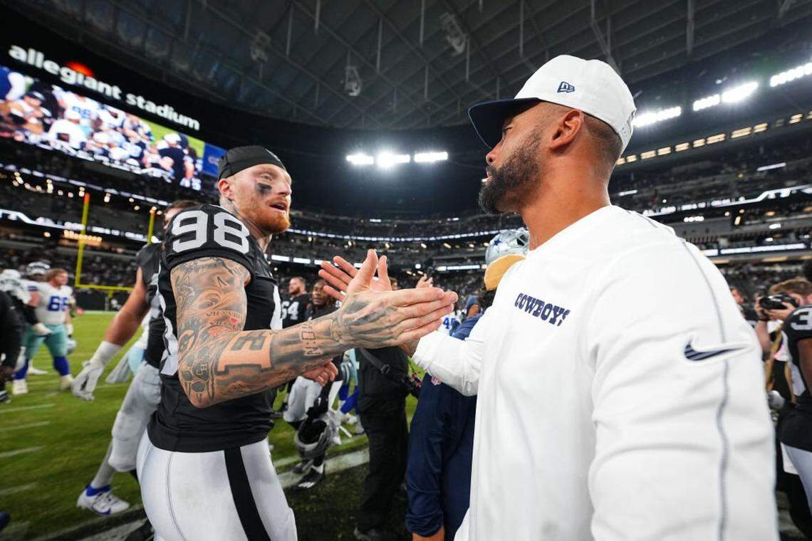 Defensive end Maxx Crosby (L) #98 of the Las Vegas Raiders and quarterback Dak Prescott #4 of the Dallas Cowboys dap each other up after their preseason game at Allegiant Stadium on August 17, 2024 in Las Vegas, Nevada.