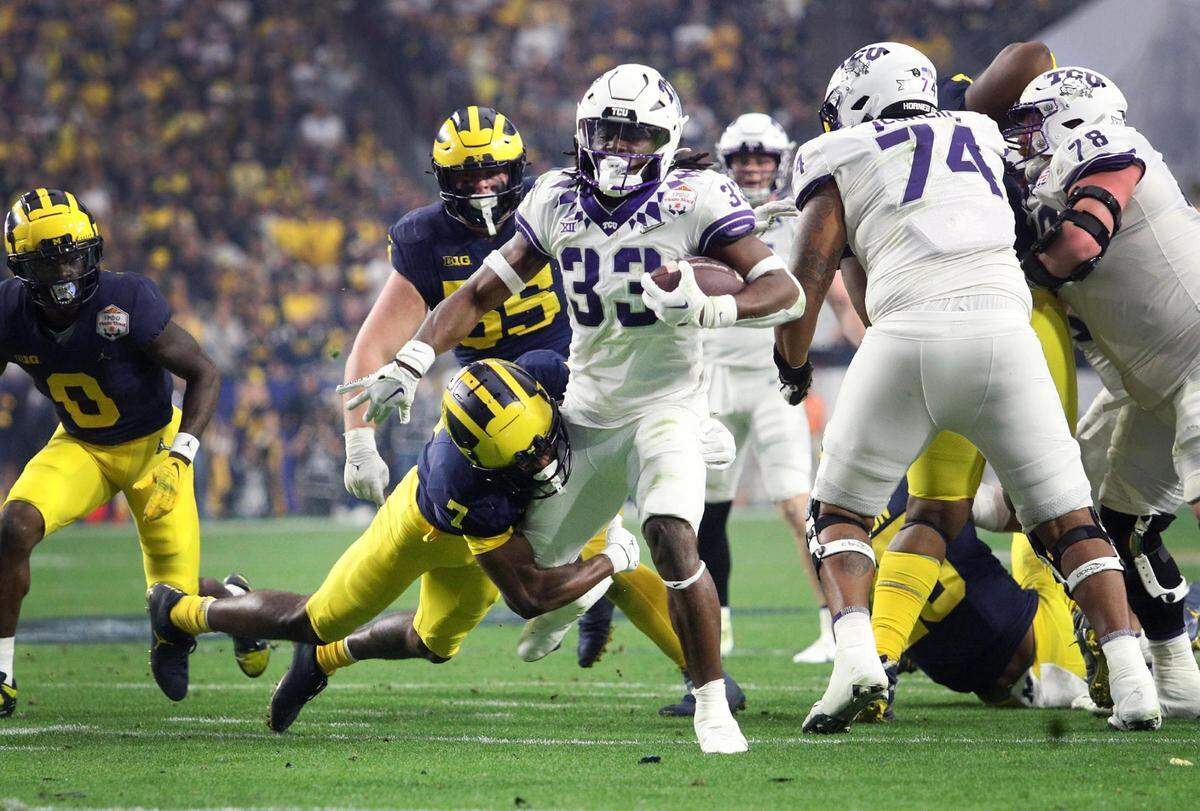TCU running back Kendre Miller moves towards the end zone while Michigan safety Makari Paige defends at the Vrbo Fiesta Bowl at State Farm Stadium in Glendale, Ariz., on Saturday, December 31, 2022.