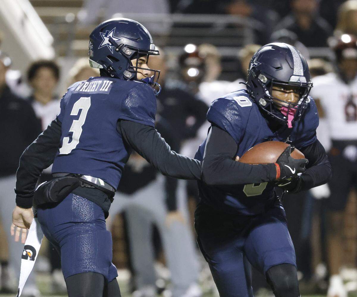 Frisco Lone Star quarterback Trey Wright hands the ball to Davian Groce during the first half of a Class 5A Division I state semifinal against Aledo on Friday at Newsom Stadium in Mansfield.