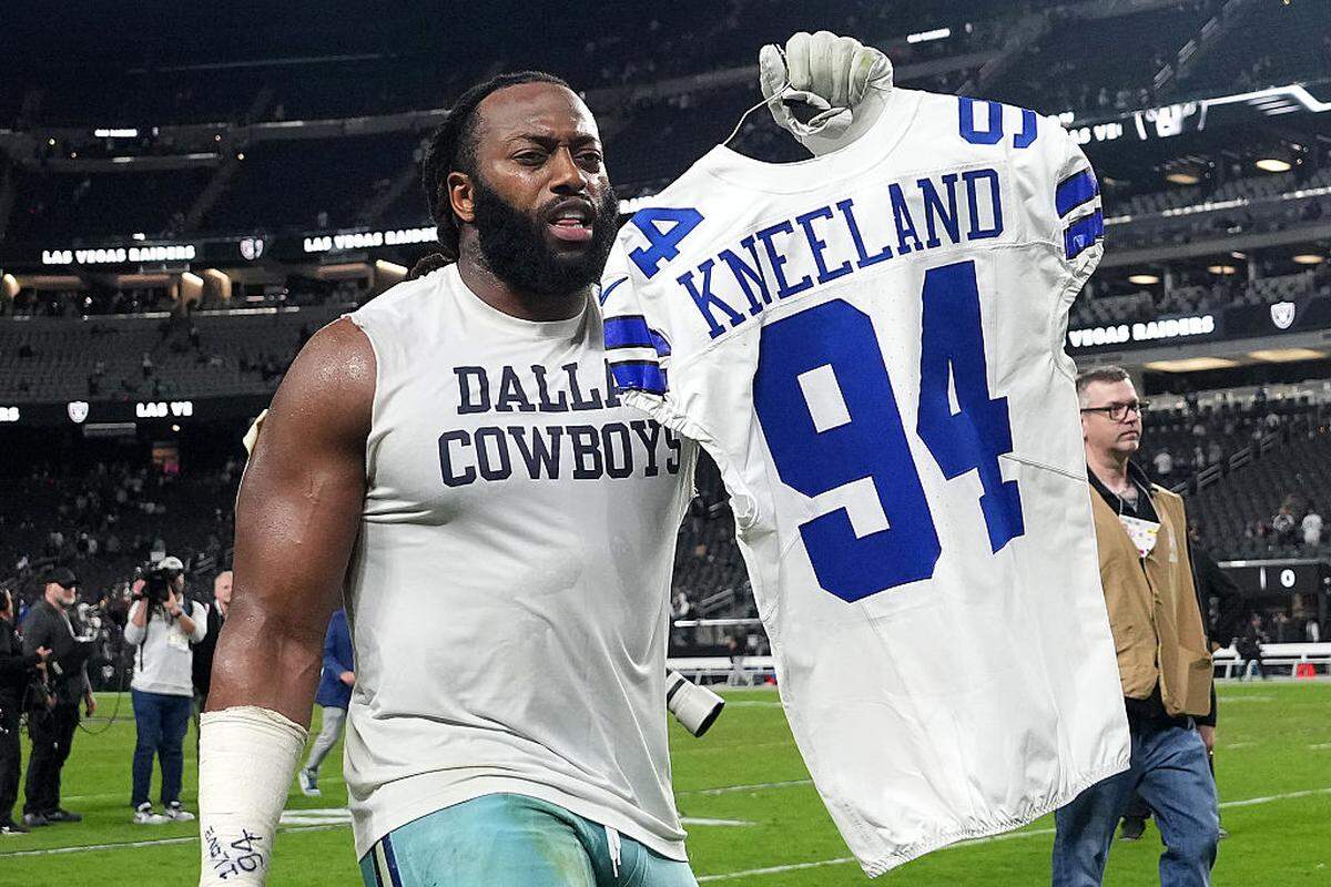 Cowboys defensive tackle Osa Odighizuwa holds up the jersey of Marshawn Kneeland after a 33-16 win over the Raiders on Monday at Allegiant Stadium in Las Vegas.