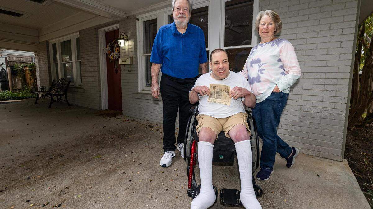 Tom Moss, left, and his wife Rosemary with their son Colby as he holds up a newspaper photo of himself when he met former First Lady Rosalyn Carter when he was 4.