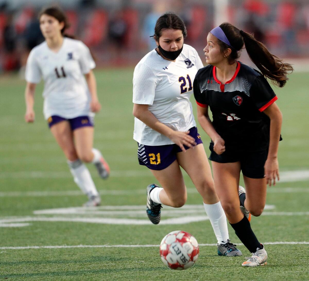 Legacy’s Sophie Stillings (11) looks to pass the ball in front of Everman’s Maria Martinez (21) during a district 8-5A high school soccer game at Mansfield Legacy High School in Mansfield, Texas, Wednesday, March 03, 2021. Legacy defeated Everman 8-0. (Special to the Star-Telegram Bob Booth)
