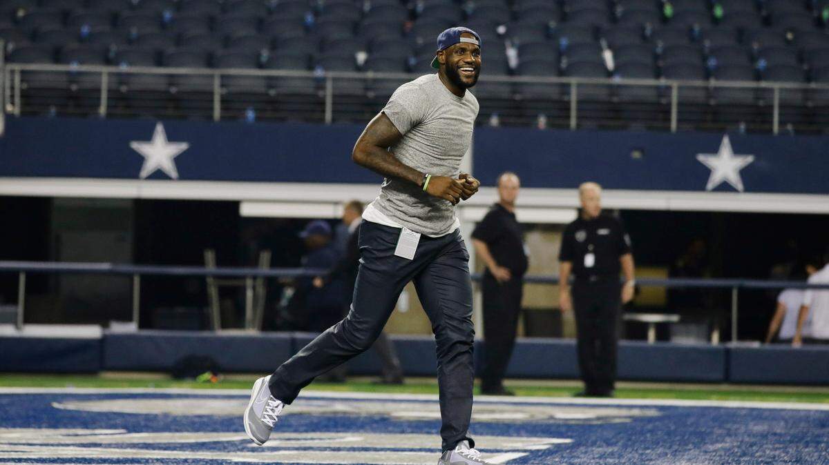 NBA basketball player LeBron James, shown in 2013, plays pick-up football on the Dallas Cowboys field. In 2022, he’s been critical of Cowboys owner Jerry Jones on several issues.
