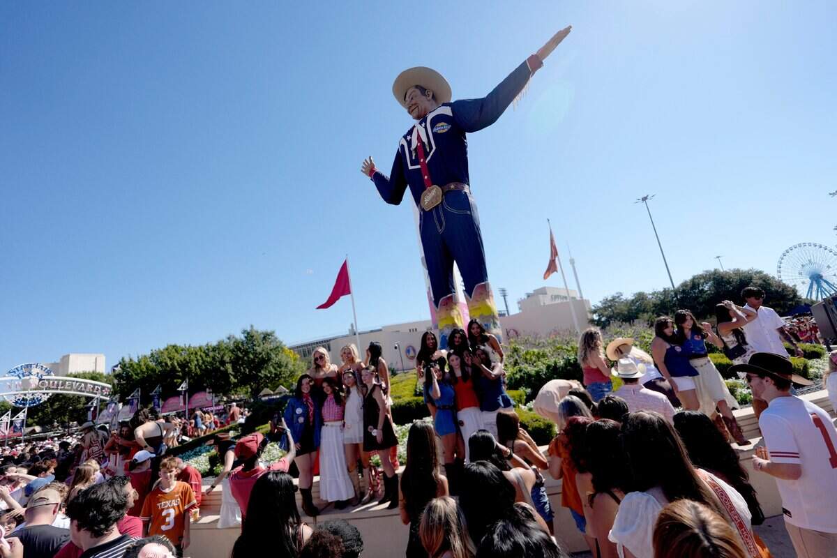 Fans take pictures at Big Tex before the Red River Rivalry college football game between the University of Oklahoma Sooners and the Texas Longhorn at the Cotton Bowl Stadium in Dallas, Texas, Saturday, Oct. 11, 2025.