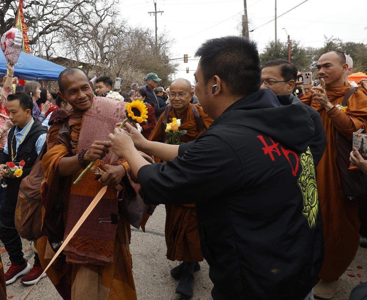 One of the Buddhist monks who walked nearly 2,300 miles to Washington D.C. for Peace receives a flower as they arrive back to the Húóng Do Vipassana Bhavana Center in Fort Worth, Texas, Saturday Feb. 14, 2026.